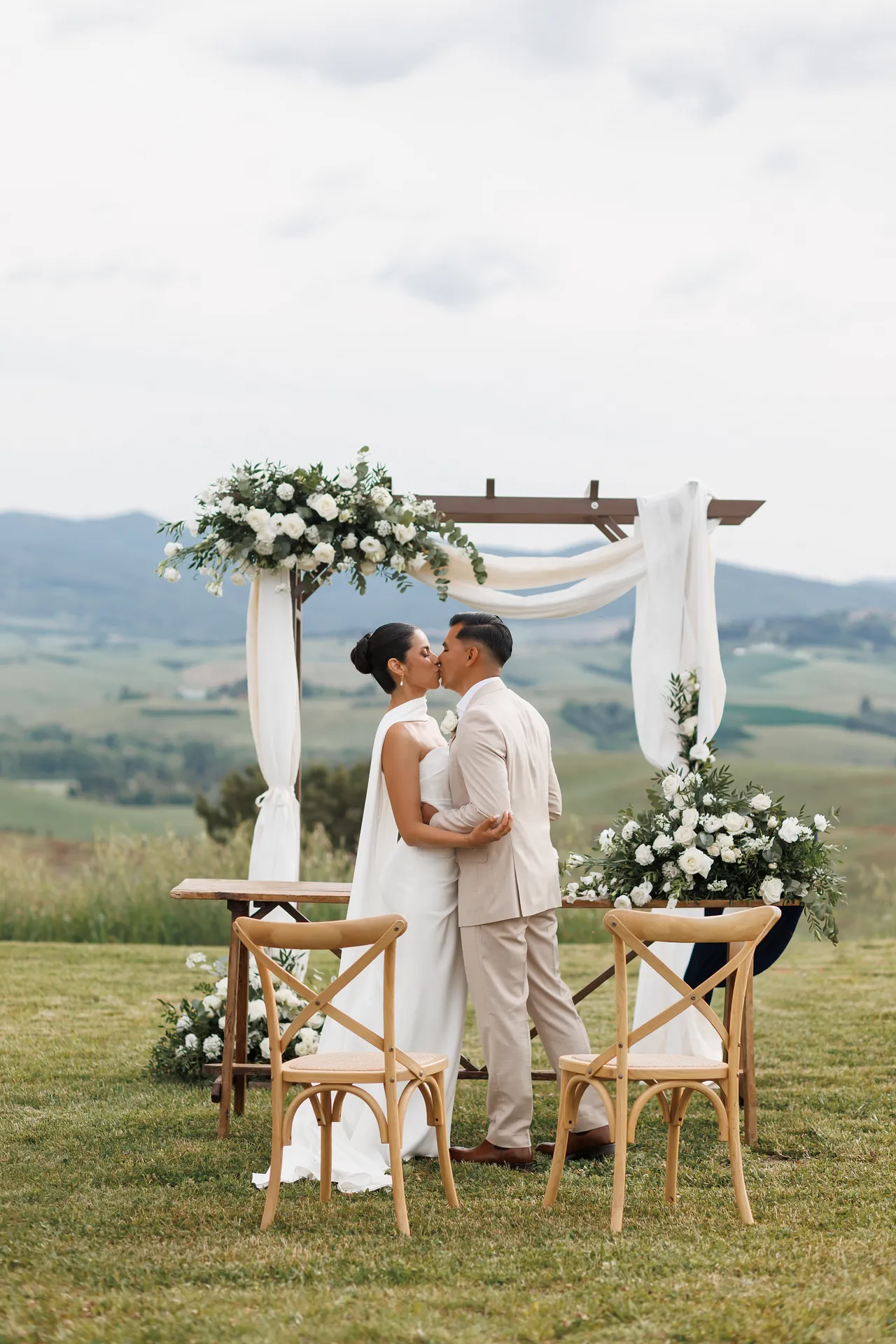 Intimate outdoor wedding ceremony setup at Villa Tosca with Tuscan hills background