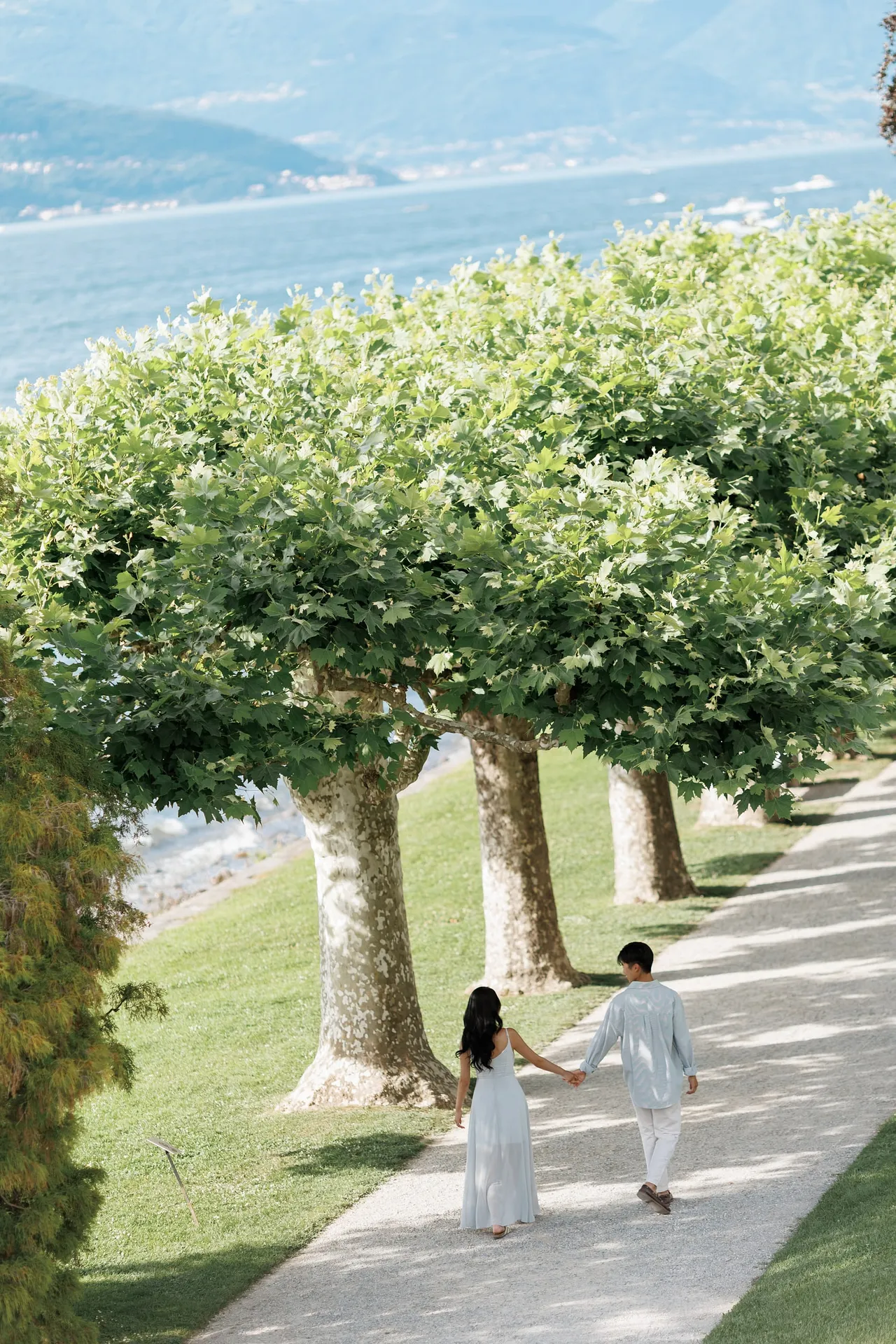 Couple walking through Villa Melzi gardens after their engagement