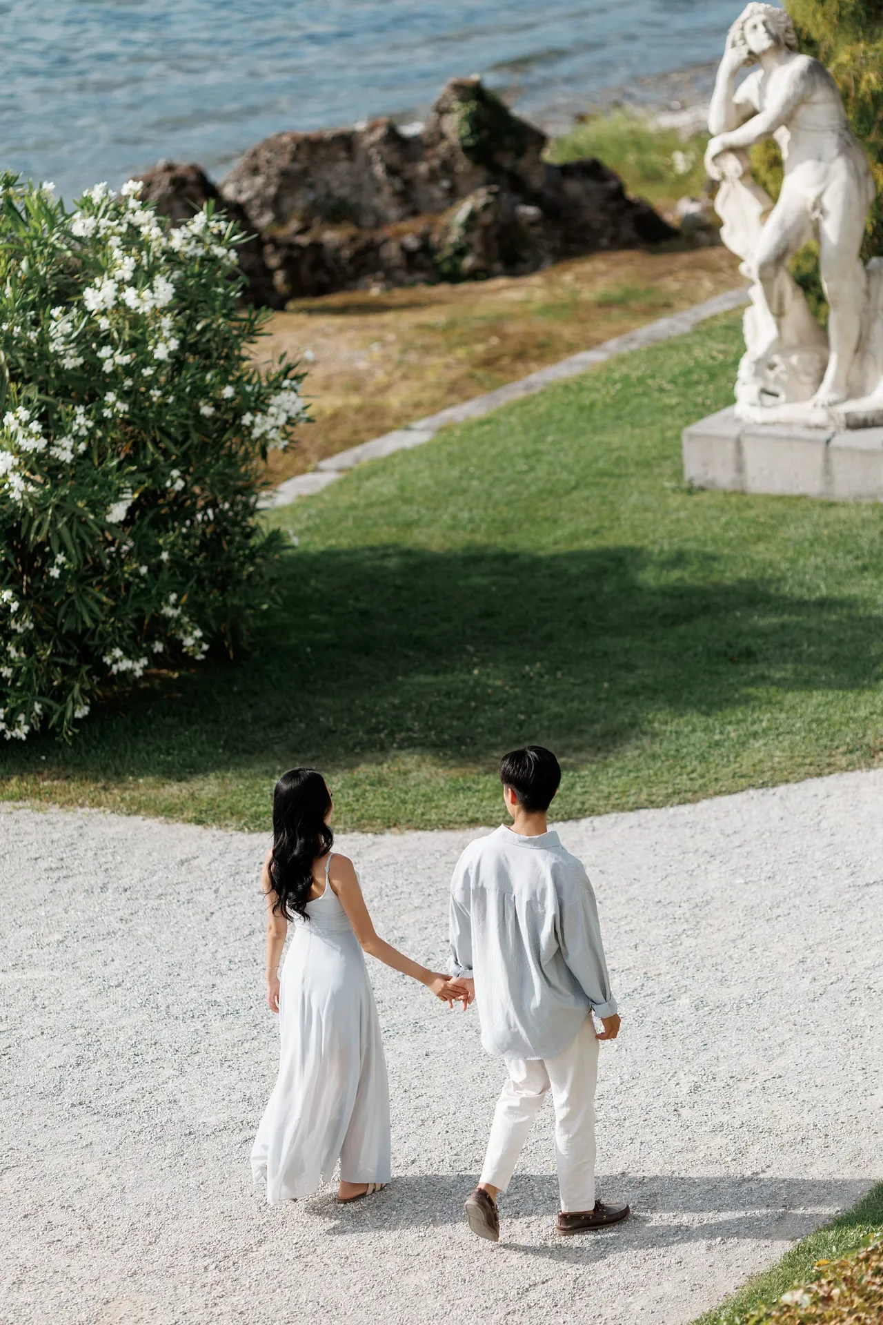 Couple walking through Villa Melzi before a surprise proposal in Bellagio